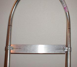 An aluminum crossbar attached to the snowshoe frame