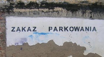 A wall reading "Zakaz parkowania"